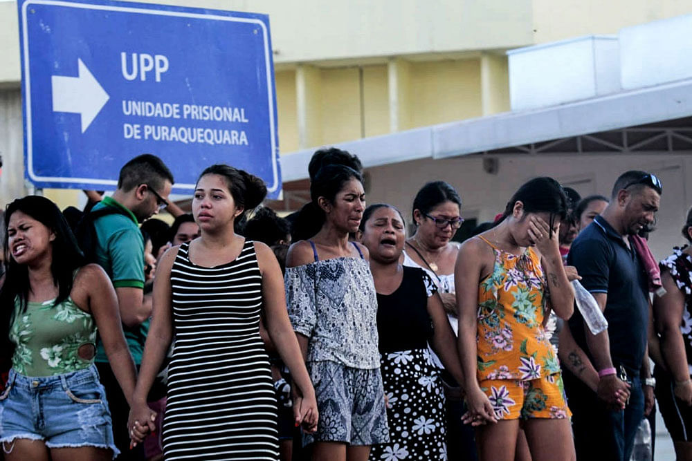 Family members of inmates are pictured praying in front of the Puraquequara Prison facility at Bela Vista community, Puraquequara neighbourhood at the city of Manaus, Amazonas state on 27 May, 2019. Photo: AFP