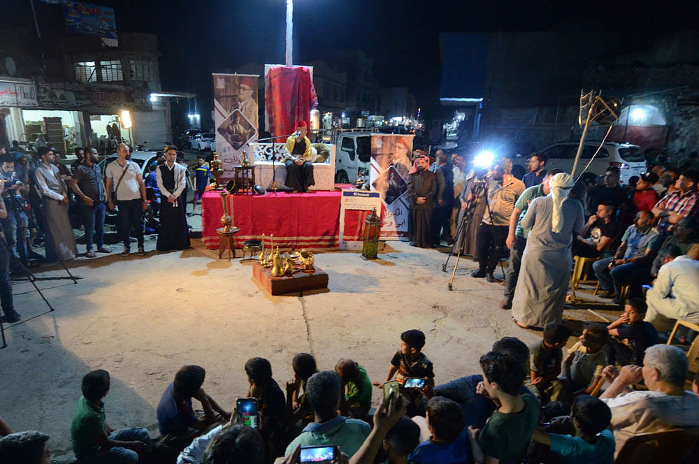 Traditional storyteller Abdel Wahed Ismail (on stage), entertains an audience in the northern Iraqi city of Mosul, during the holy Muslim month of Ramadan on 17 May 2019. In Iraq, as in other Muslim countries, the annual month of dawn-to-dusk fasting is a time for evening gatherings in restaurants, coffee shops or homes of family and friends across Iraq. Photo: AFP