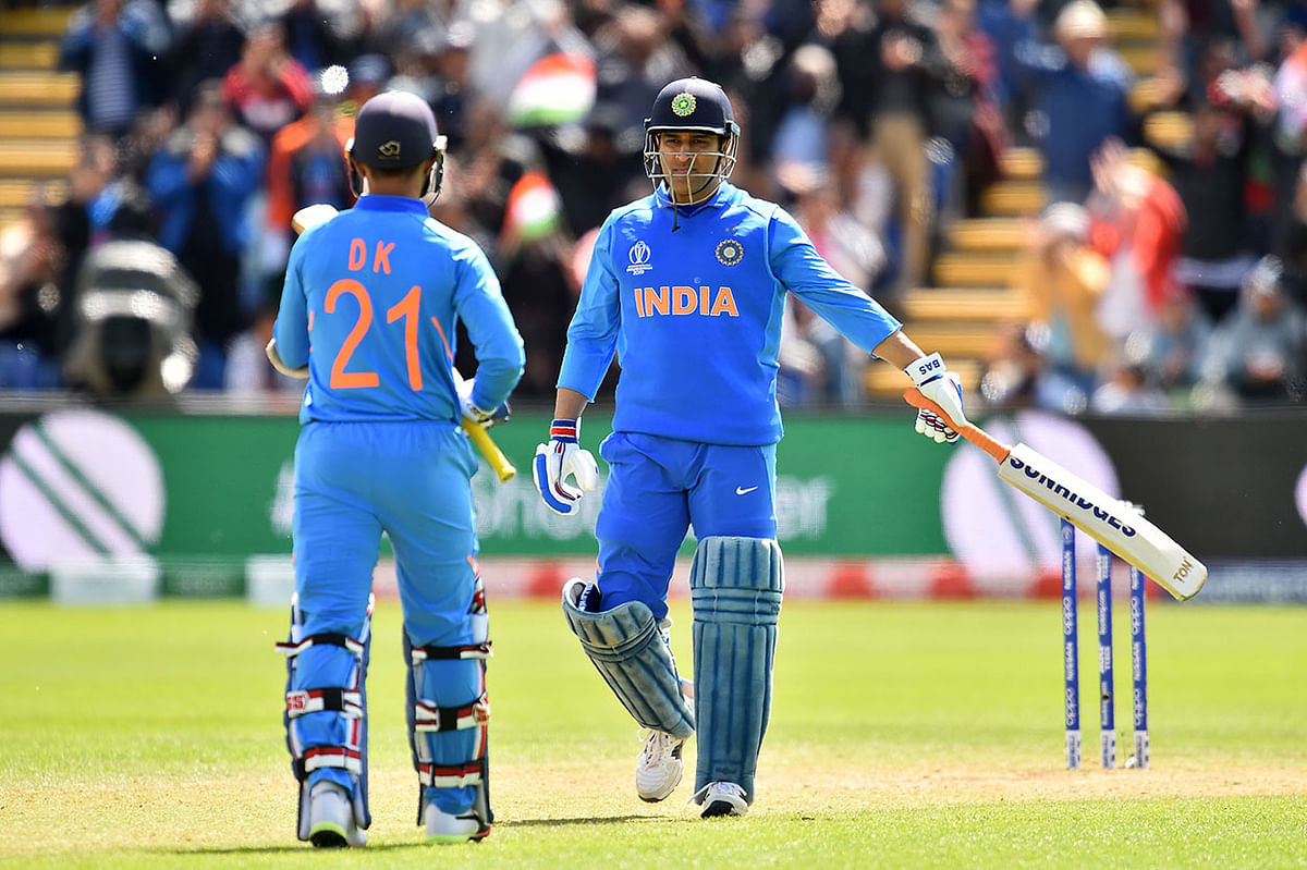 India`s Mahendra Singh Dhoni (R) celebrates his century with India`s Dinesh Karthik during the 2019 Cricket World Cup warm up match between Bangladesh v India at Sophia Gardens stadium in Cardiff, south Wales, on 28 May 2019. Photo: AFP