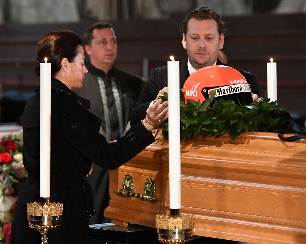 Birgit Lauda (C), widow of formular Formula One driver Niki Lauda and his sons Mathias Lauda (L) and Lukas Lauda (R) put Lauda`s racing helmet on top of his coffin during a funeral service at St Stephen`s Cathedral (Stephansdom) in Vienna, Austria, on 29 May, 2019. Photo: AFP