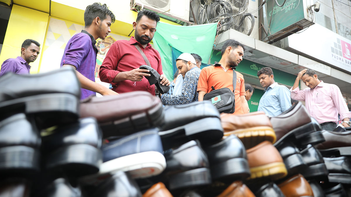 Customers look at shoes at a market during the month of Ramadan and ahead of Eid al-Fitr celebrations in Motijheel, Dhaka on 29 May 2019 Photo: Abdus Salam