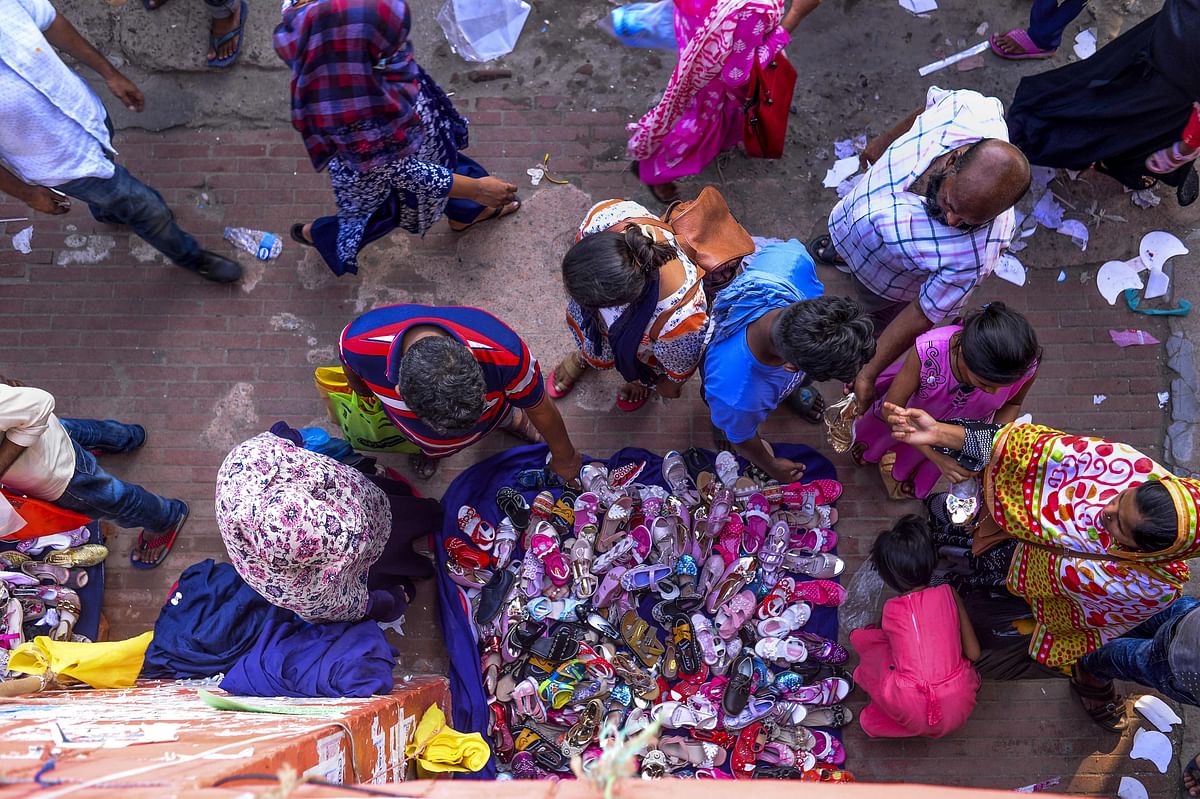 Bangladeshi customers look at shoes sold at a market during the month of Ramadan and ahead of Eid al-Fitr celebrations in Dhaka on 28 May 2019. Photo: AFP