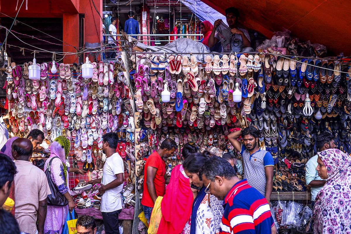 Bangladeshi customers walk past a shoe seller at a market during the month of Ramadan and ahead of Eid al-Fitr celebrations in Dhaka on 28 May 2019. Photo: AFP