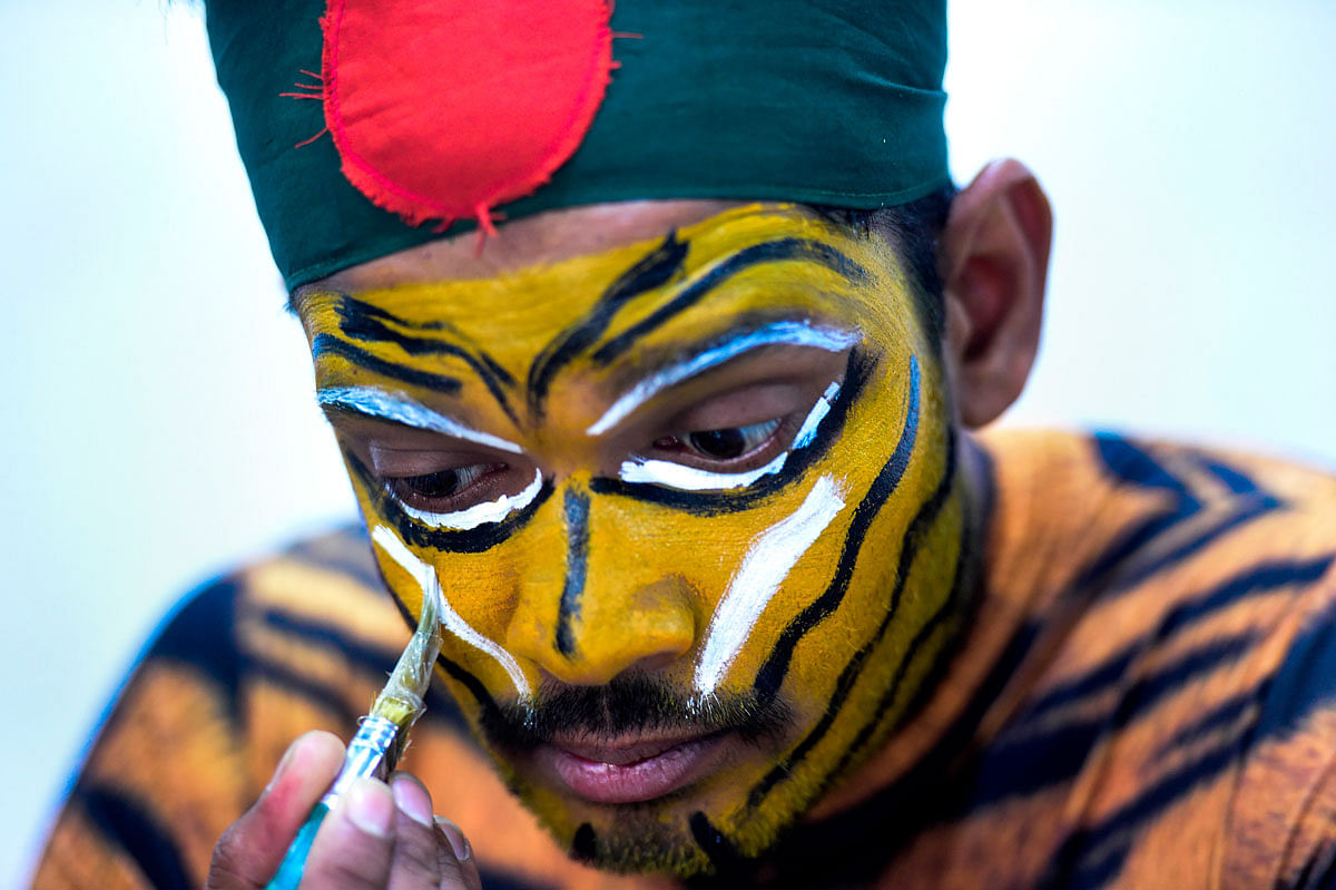 This picture taken on 25 May 2019, shows Bangladeshi cricket fan Shoyab Ali applying make up on his face after an interview with AFP in Dhaka. Photo: AFP