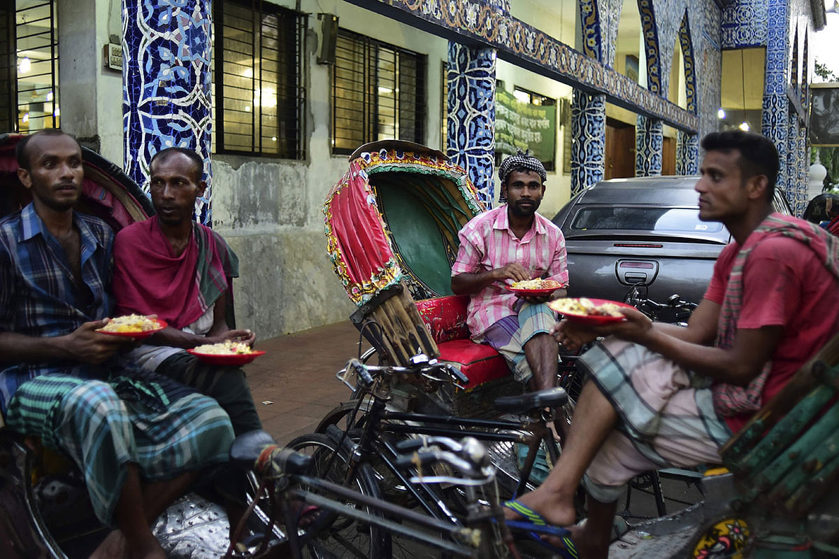 Bangladeshi rickshaw pullers break their fast during the holy month of Ramadan at a shrine in Dhaka on 30 May, 2019. Photo: AFP
