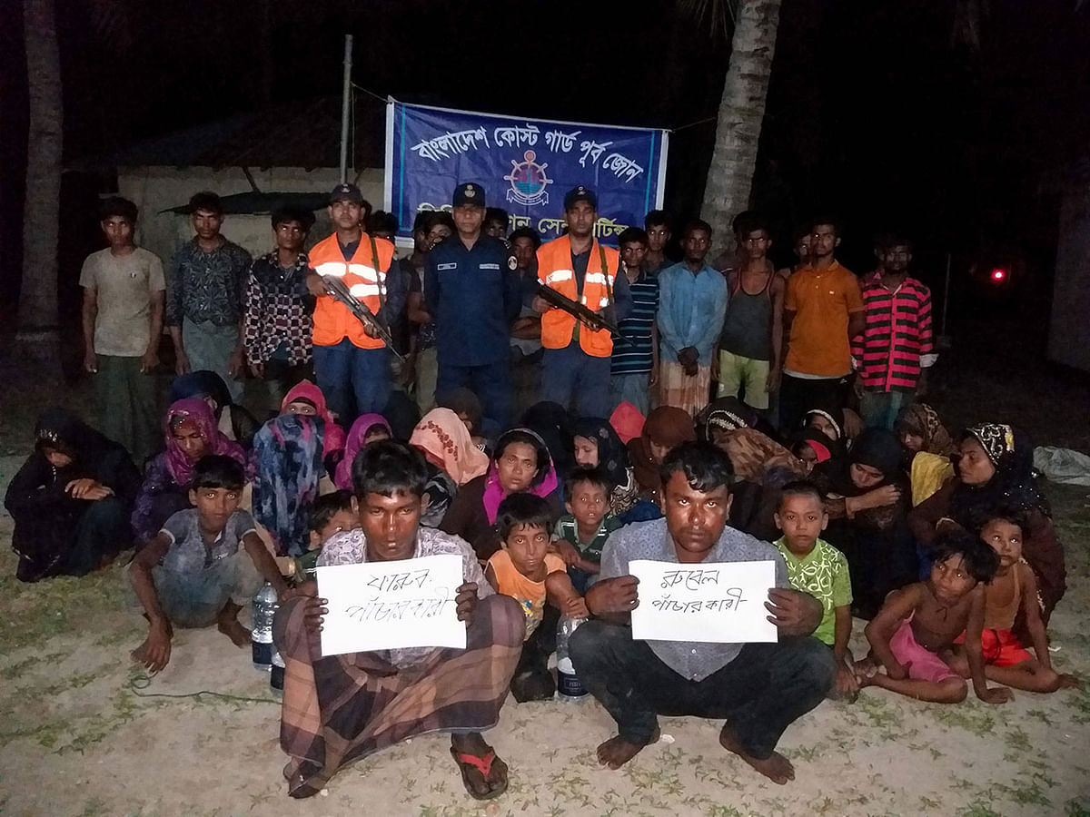 Bangladesh Coast Guard pose for a photo with rescued Rohingya refugees in Teknaf on 31 May, 2019. Photo: AFP