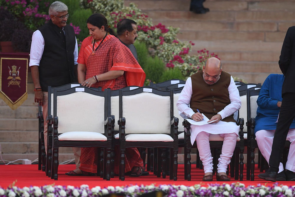 Bharatiya Janata Party president Amit Shah (R) takes notes before Narendra Modi`s swearing-in ceremony as India`s Prime Minister at the President house in New Delhi on 30 May 2019. Photo: AFP