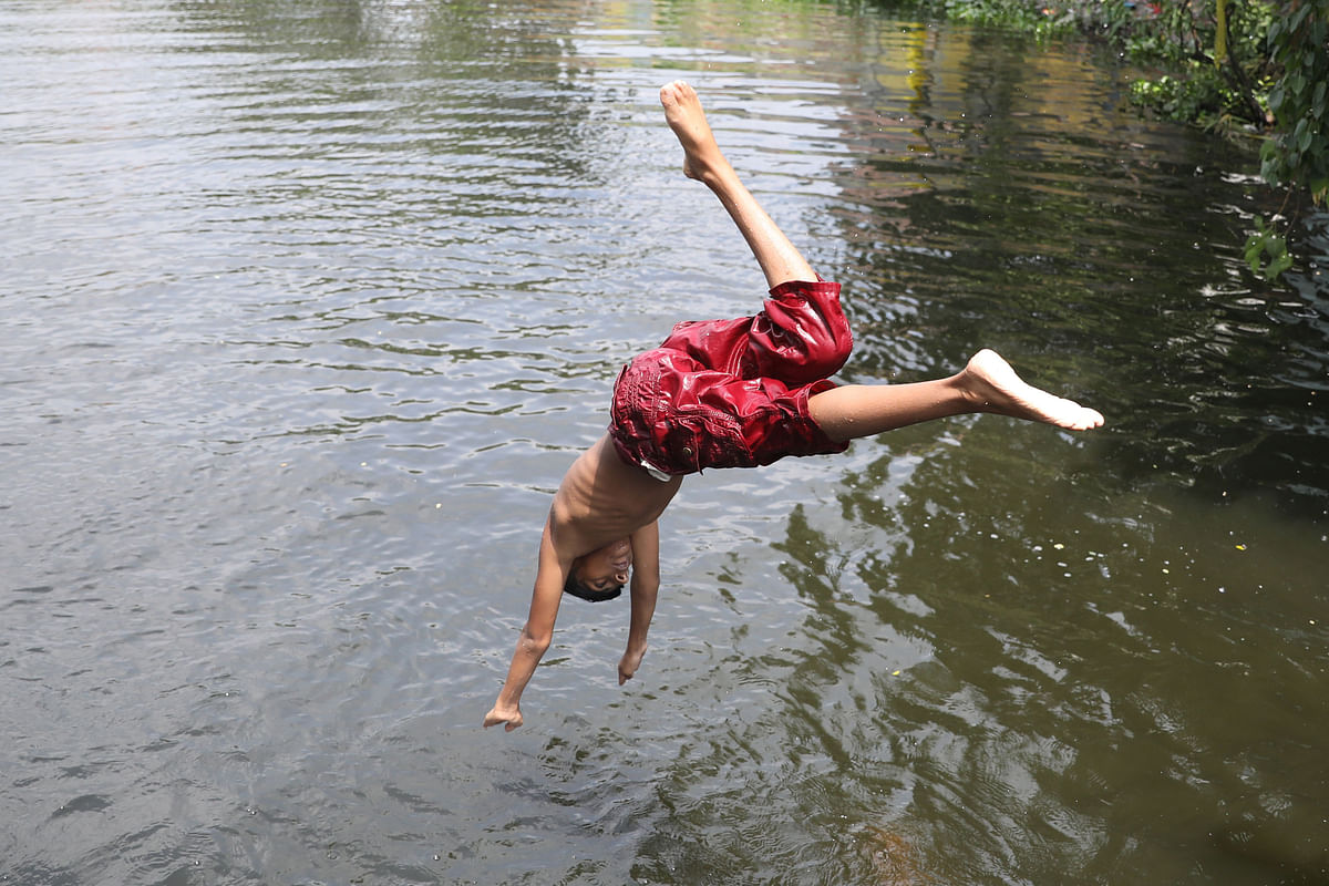 A child dives into the water during a hot day at Matuail, Dhaka. 30 May 2019. Photo: Abdus Salam