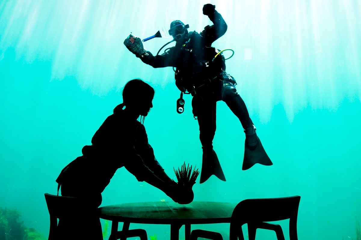 This file photo taken on 2 May 2019 shows a diver cleaning the outside of a viewing window of Under, a restaurant that is semi-submerged beneath the waters of the North Sea in Lindesnes near Kristiansand, some 400 km south west of Oslo. Photo: AFP