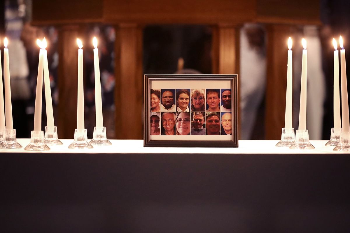 A photograph of the victims of a mass shooting is surrounded by 12 candles during a memorial service at Piney Grove Baptist Church on 2 June 2019 in Virginia Beach, Virginia. Photo: AFP