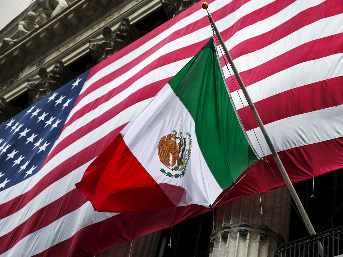The flag of Mexico changes in front of a large US flag in front of the New York Stock Exchange on 4 September 2015. Reuters File Photo