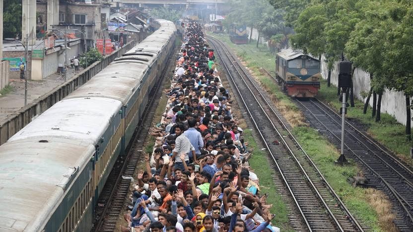 People are heading for village home from Dhaka at the last moment to celebrate Eid-ul-Fitr with their nearest ones. Unable to board inside, people get into the roof of train on their way home. Basabo, Dhaka, 4 June, 2019. Photo: Abdus Salam.