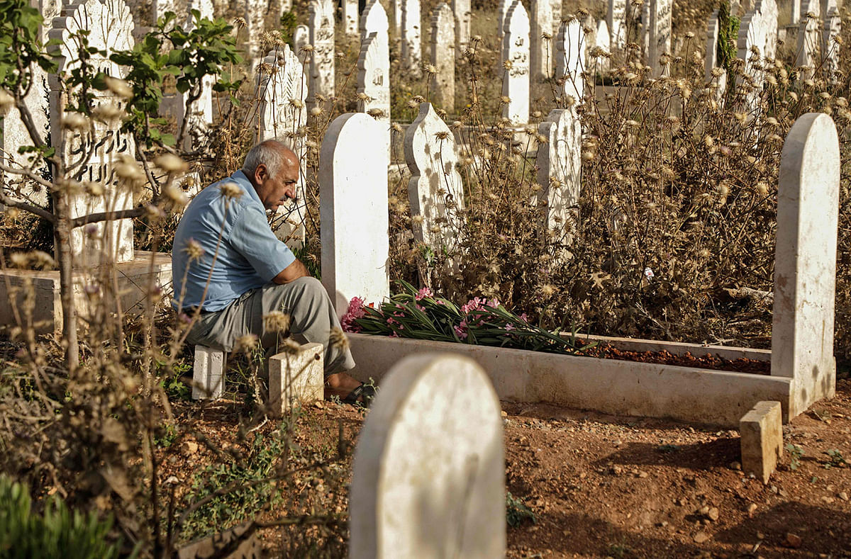 A man sits visits the grave of a relative on the first day of Eihe Eid al-Fitr at in the rebel-held Syrian northwestern city of Idlib on June 4, 2019.