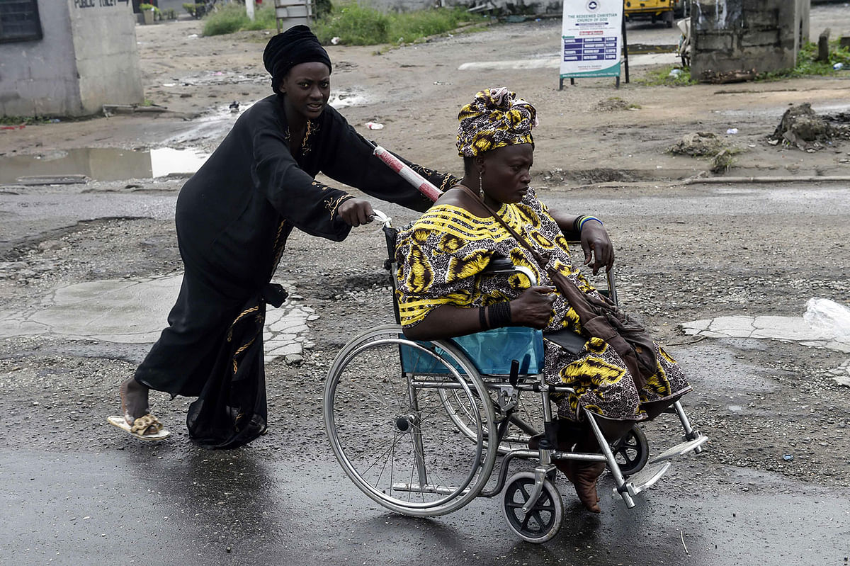 A woman arrives in a wheel chair to take part in Eid al-Fitr prayers at the National Stadium sport complex of Surulere neighbourhood in Lagos on 4 June, 2019. Muslims worldwide are celebrating Eid al-Fitr which marks the end of the Muslim holy month of Ramadan. Photo: AFP
