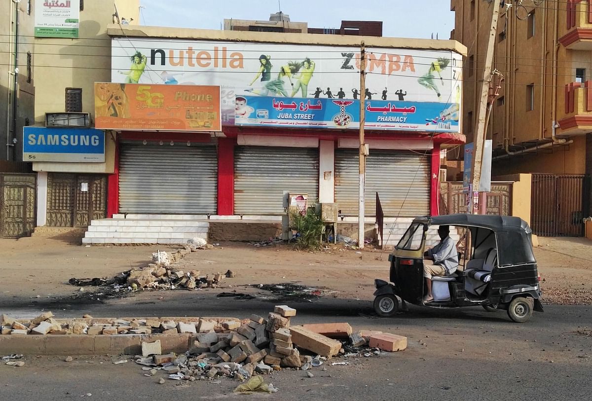 A Sudanese man drives his tuqtuq past closed shops in a residential neighbourhood of Sudan`s capital Khartoum on 4 June. Photo: AFP