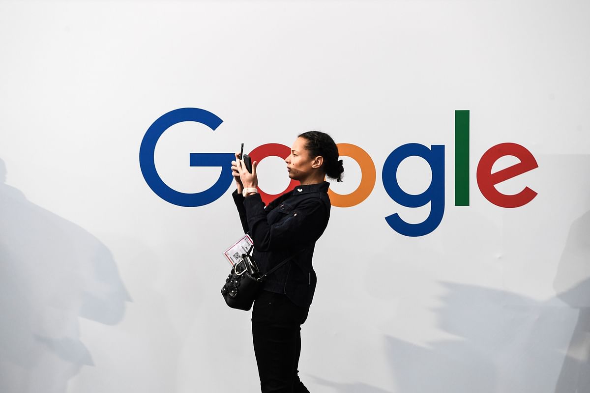 a woman takes a picture with two smartphones in front of the logo of the US multinational technology and Internet-related services company Google as he visits the Vivatech startups and innovation fair, in Paris. Photo: AFP