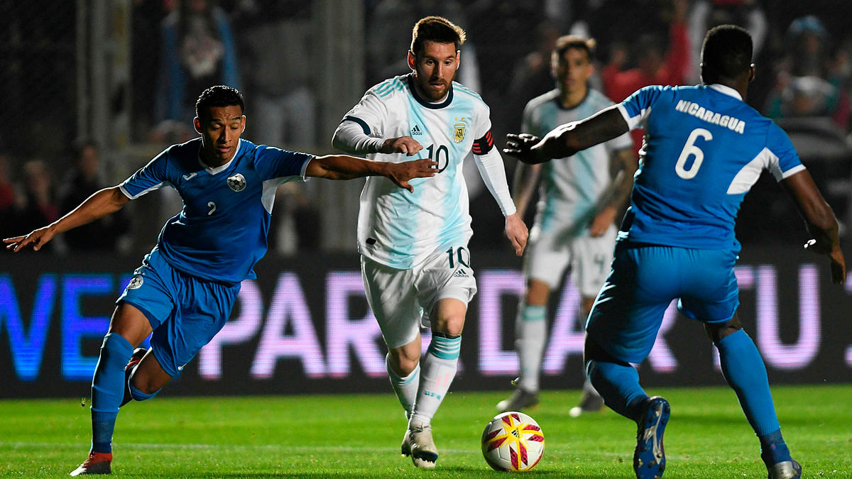 Argentina`s Lionel Messi (C) is marked by Nicaragua`s Josue Quijano (L) and Luis Fernando Copete during their international friendly football match at the San Juan del Bicentenario stadium in San Juan, Argentina, on 7 June. Photo: AFP