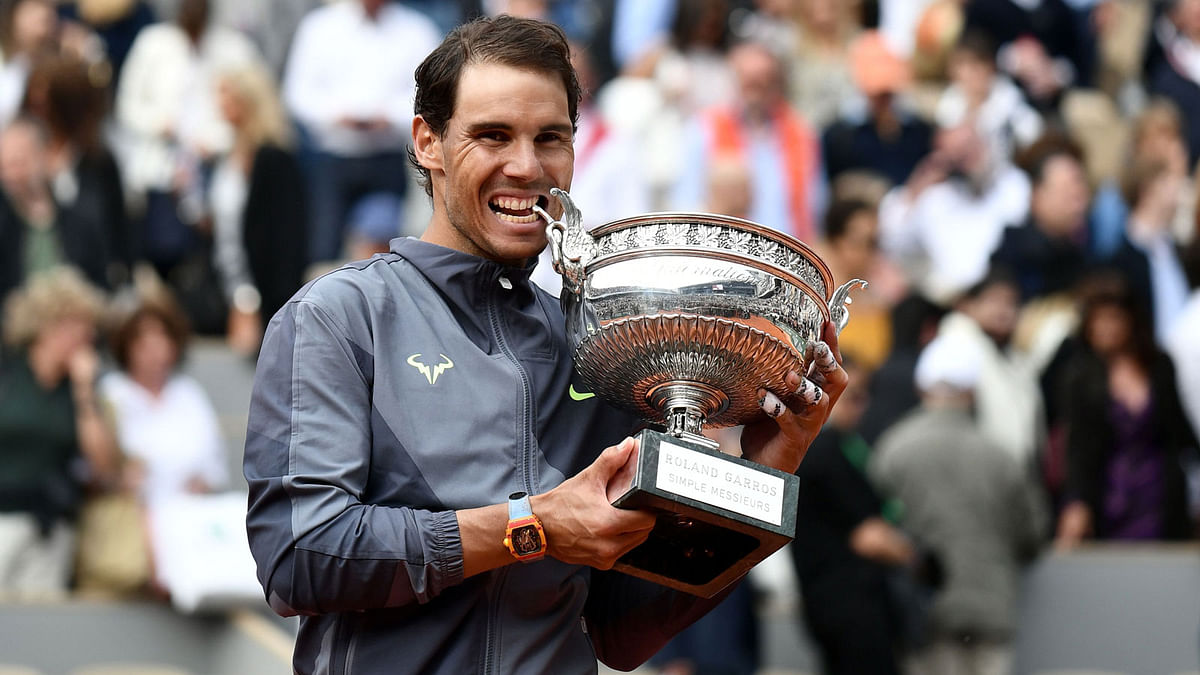 Spain`s Rafael Nadal bites the Mousquetaires Cup (The Musketeers) as he poses at the end of the men`s singles final match against Austria`s Dominic Thiem on day fifteen of The Roland Garros 2019 French Open tennis tournament in Paris on 9 June, 2019. Photo: AFP
