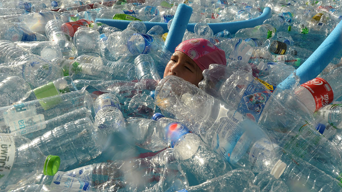A child swims in a pool filled with plastic bottles during an awareness campaign to mark the World Oceans Day in Bangkok on 8 June. Photo: AFP Tag: Canada, Plastic, Pollution