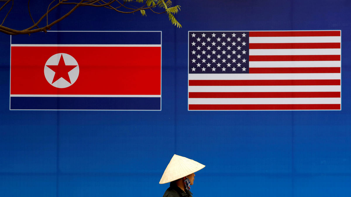 A person walks past a banner showing North Korean and US flags ahead of the North Korea-US summit in Hanoi, Vietnam on 25 February. Photo: Reuters