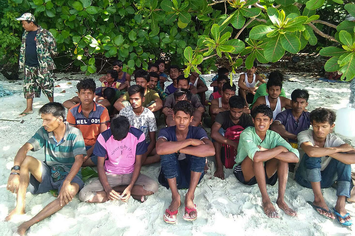 This handout picture taken on 11 June 2019 and released by Department of National Parks, Wildlife and Plant Conservation (DNP) on 12 June shows a group of Rohingya Muslims sitting on the sand at the Tarutao Marine National Park on Rawi island, southern Thailand. Photo: AFP