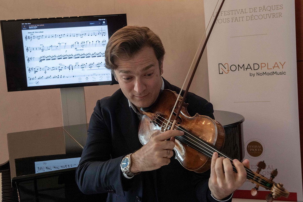 In this file photo taken on 16 April 2019 in Aix en Provence, southern France, French violinist Renaud Capucon practices with the new application `NomadPlay`, created by the French start-up Digital Music Solutions, which can replace virtually every orchestral musician. Photo: AFP