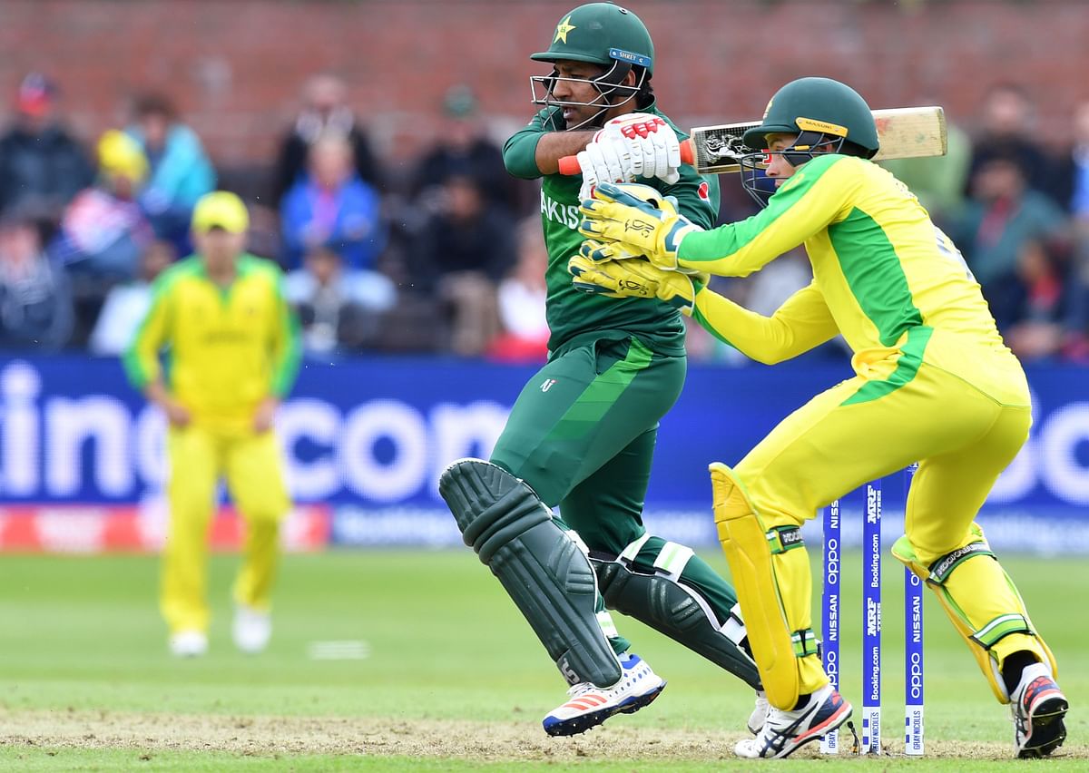 Pakistan`s captain Sarfaraz Ahmed (L) is watched by Australia`s Alex Carey as he plays a shot during the 2019 Cricket World Cup group stage match at The County Ground in Taunton, southwest England, on 12 June 2019. Photo: AFP