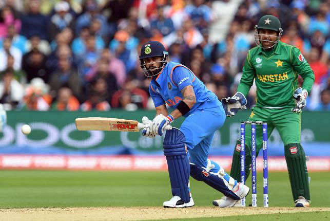 India’s Virat Kohli (L) bats as Pakistan wicket-keeper Sarfraz Ahmed ® looks on during the ICC Champions trophy match between India and Pakistan at Edgbaston in Birmingham. Photo: AFP