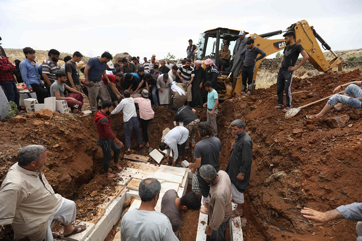 Syrians bury the victims of air strike on the village of Kafr Aweid on 5 June in which five people, including two children, were killed in the country`s northern Idlib province. Photo: AFP