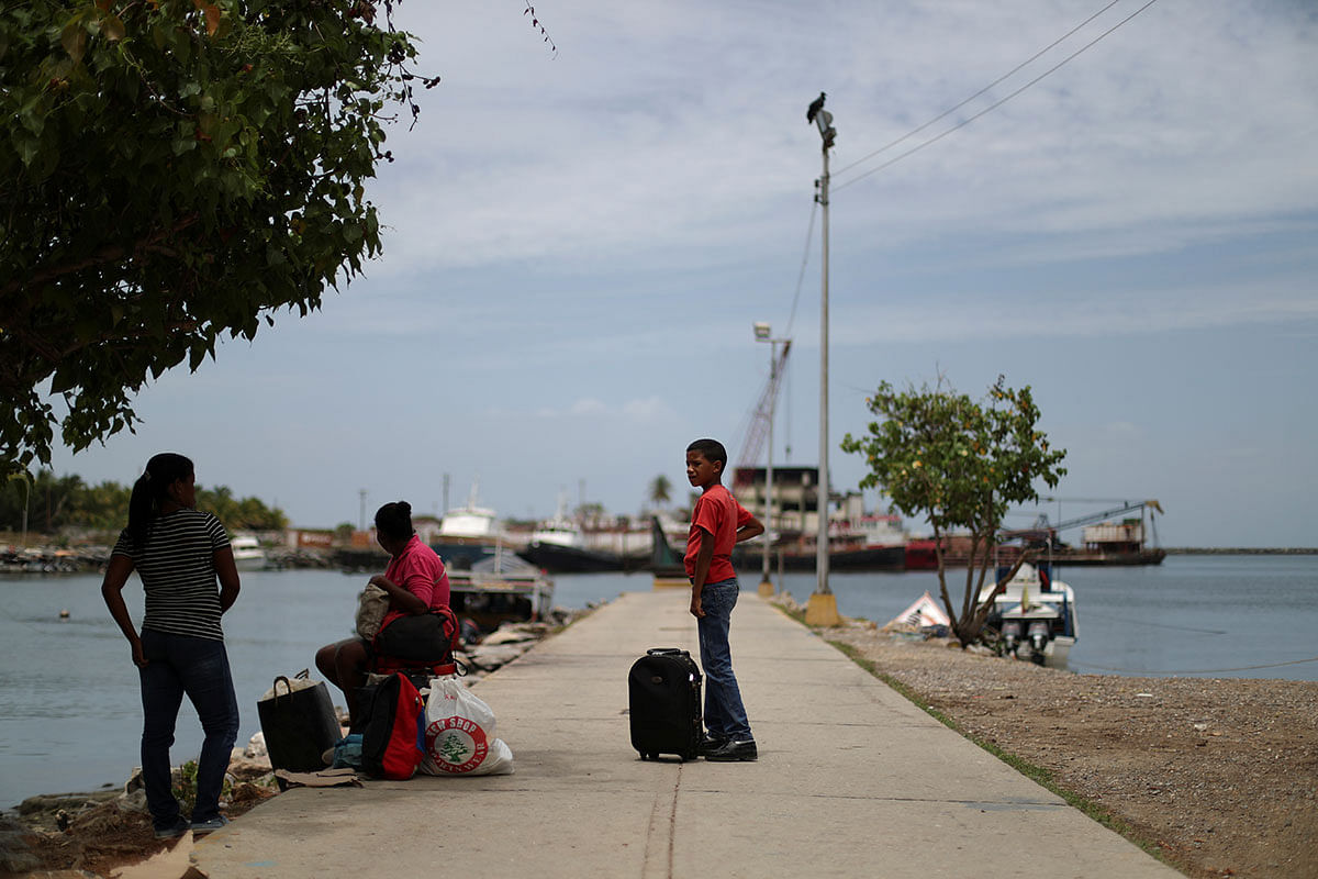A friend of Maroly Bastardo, an eight months pregnant woman who, along with her children, her husband`s sister, uncle and father, disappeared in the Caribbean Sea after boarding a smuggler`s boat during an attempt to cross from Venezuela to Trinidad and Tobago, shows a picture of the boat that Bastardo and her family boarded, in Guiria, Venezuela on 24 May. Photo: Reuters