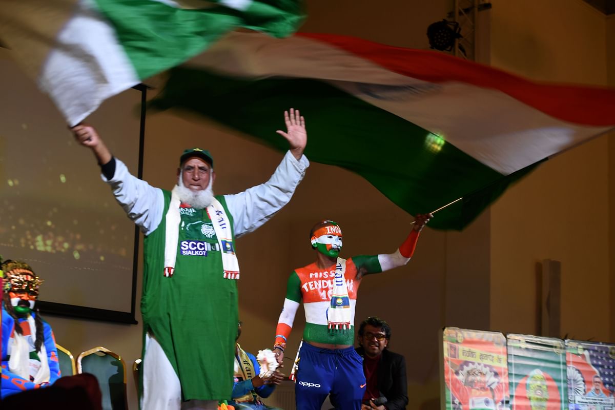 Pakistan cricket fan `Chacha Cricket`, AKA Chacha Sufi Jalil (L) and Indian cricket fan Sudhir Gautam wave flags at a super-fan event in Manchester on 14 June 2019, ahead of the India v Pakistan 2019 World Cup cricket match. Photo: AFP