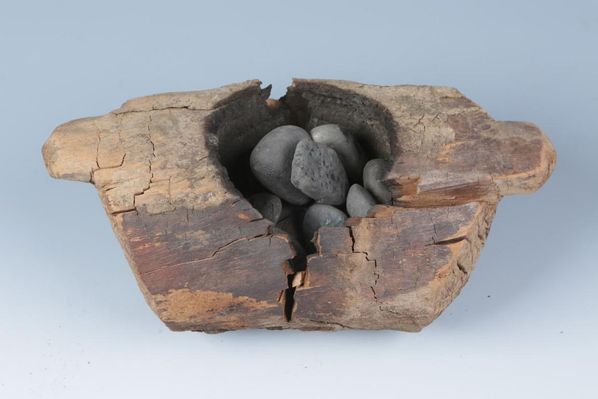 In this photo received by AFP on 11 June 2019 from the Institute of Archaeology, Chinese Academy of Social Sciences, a wooden brazier (burner) and stones used to burn cannabis that was excavated from the Jirzankal cemetery, located northeast of Qushiman Village in the Tashkurgan Tajik Autonomous County of Xinjiang province, is displayed.