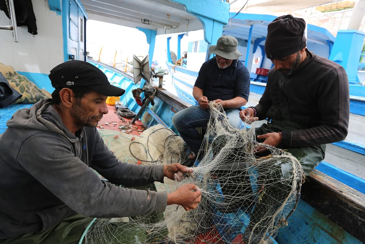 Tunisian fishermen prepare their nets inside a boat in the port of Zarzis in the southern coast of Tunisia on 21 May 2019. Photo: AFP