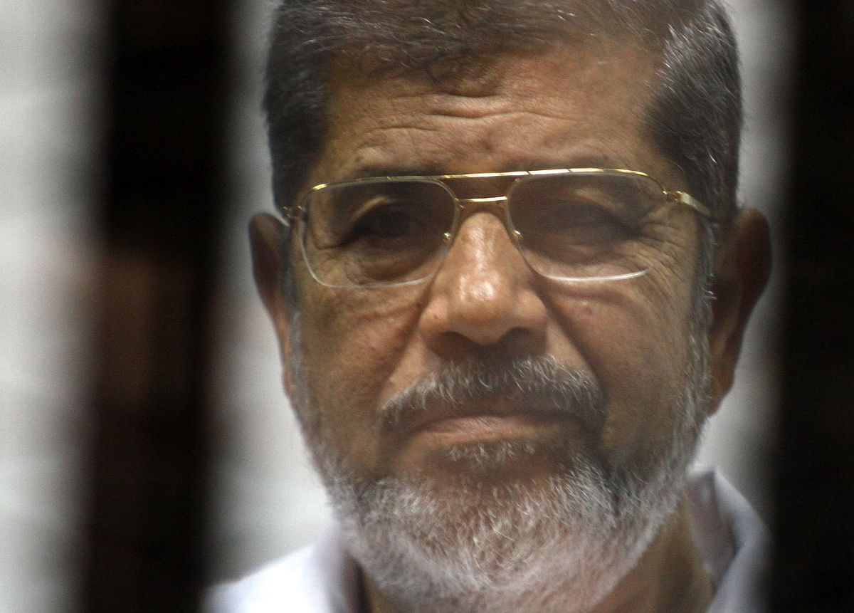 In this file photo taken on May 09, 2014 Egyptian ousted Islamist president Mohamed Morsi looks on from behind the defendants cage during is trial alongside 130 others on charges of organising jail breaks during the 2011 uprising that toppled strongman Hosni Mubarak. Photo: AFP