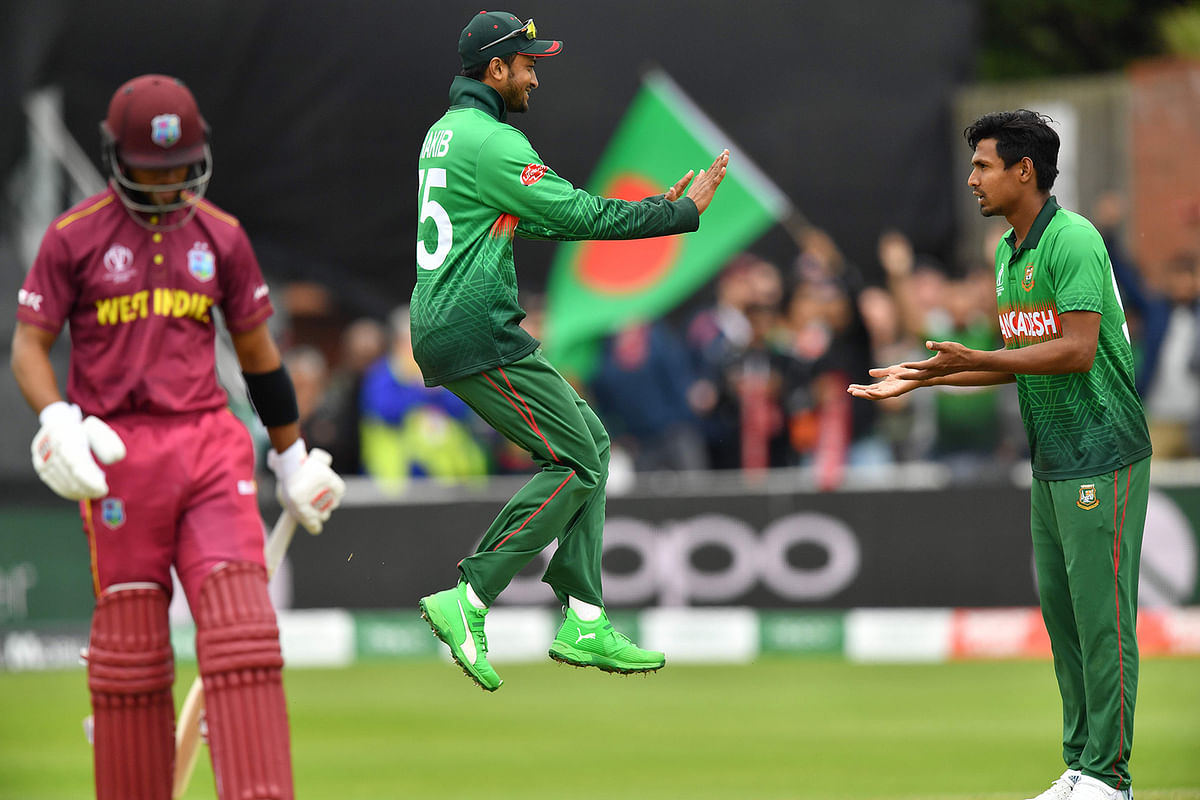 Mustafizur Rahman (R) celebrates with Shakib Al Hasan (C) after taking the wicket of Andre Russell (L). AFP