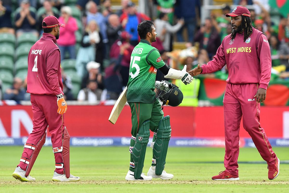 West Indies` Chris Gayle (R) shakes hands with Bangladesh`s Shakib Al Hasan during the 2019 Cricket World Cup group stage match between West Indies and Bangladesh at The County Ground in Taunton, southwest England, on 17 June 2019. Photo: AFP