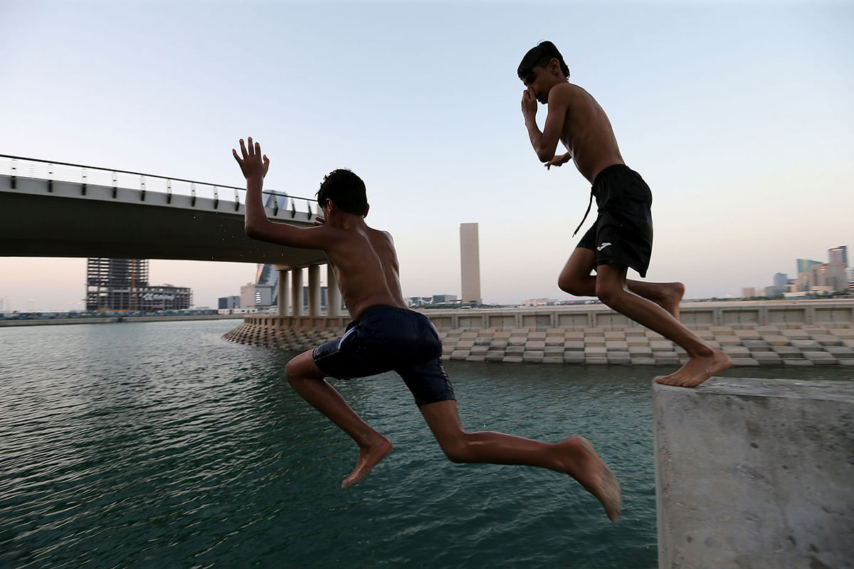 Kids jump on the man-made canal at Bahrain Bay to cool themselves from summer heat in Manama, Bahrain, June 20, 2019. Picture taken 20 June 2019. Photo: Reuters