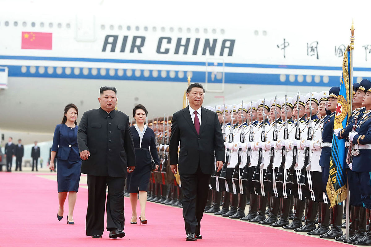 This 20 June 2019 picture released by North Korea`s official Korean Central News Agency (KCNA) on 21 June 2019 shows North Korean leader Kim Jong Un (L) walking with Chinese President Xi Jinping upon his arrival at Pyongyang international airport in Pyongyang. Photo: AFP