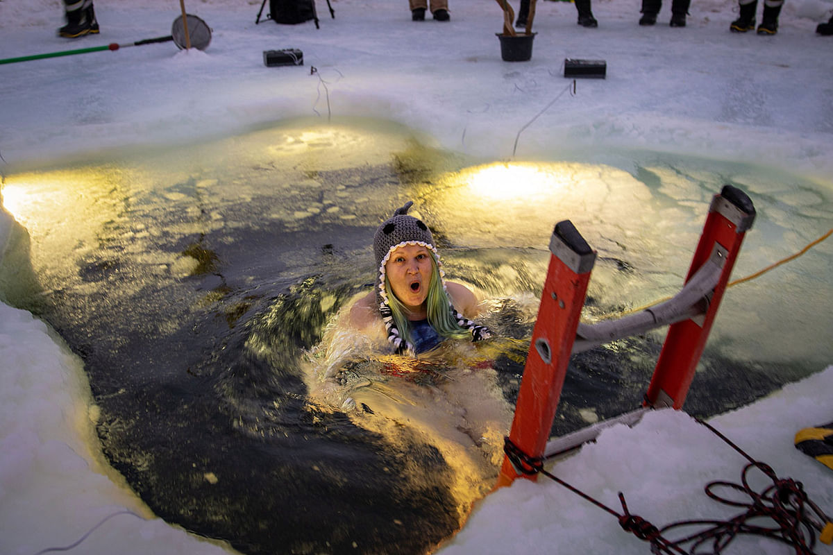 This handout photo taken on 20 June 2019 and released by the Australian Antarctic Division (AAD) shows Weather Observer Amy Geels swimming in an icy pool as part of midwinter celebrations at Australia’s Davis research station where it`s -23 degrees Celsius on the ice and -1.5 degrees Celsius in the water. Photo: AFP