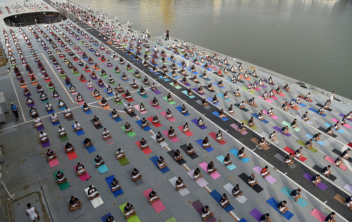 Indian Armed Forces personnel take part in a yoga session to mark International Yoga Day on the Indian Navy aircraft carrier INS Viraat anchored at the harbour in Mumbai on 21 June 2019. / AFP