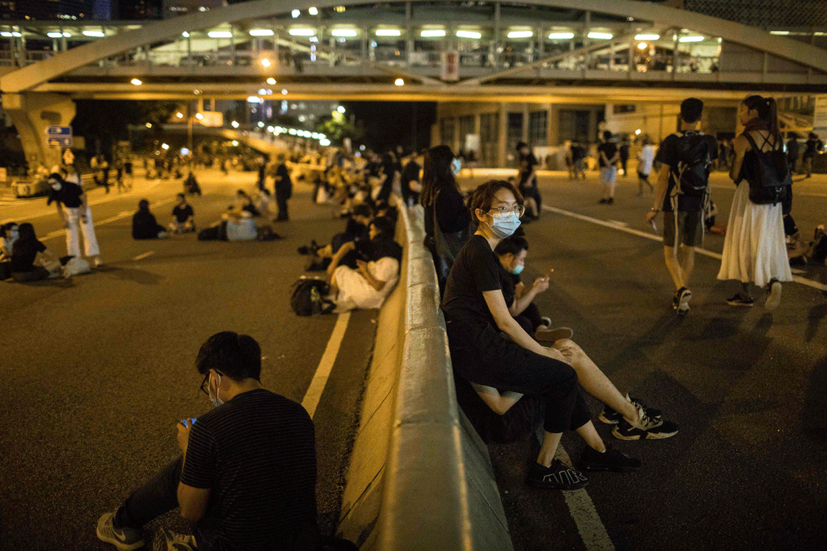 In this picture taken on 21 June protesters relax on a main road near the government headquarters in Hong Kong. Photo: AFP