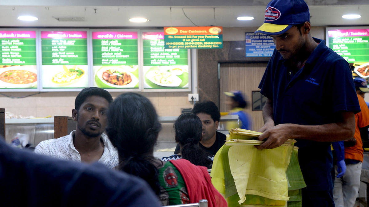 In this photo taken on 20 June 2019, an Indian waiter hands out banana leaves used to serve food on instead of plates to save water at a hotel in Chennai after reservoirs for the city ran dry. The drought is the worst in living memory for the bustling capital of Tamil Nadu state, India`s sixth largest city, that is getting less than two thirds of the 830 million litres of water it normally uses each day. Photo: AFP