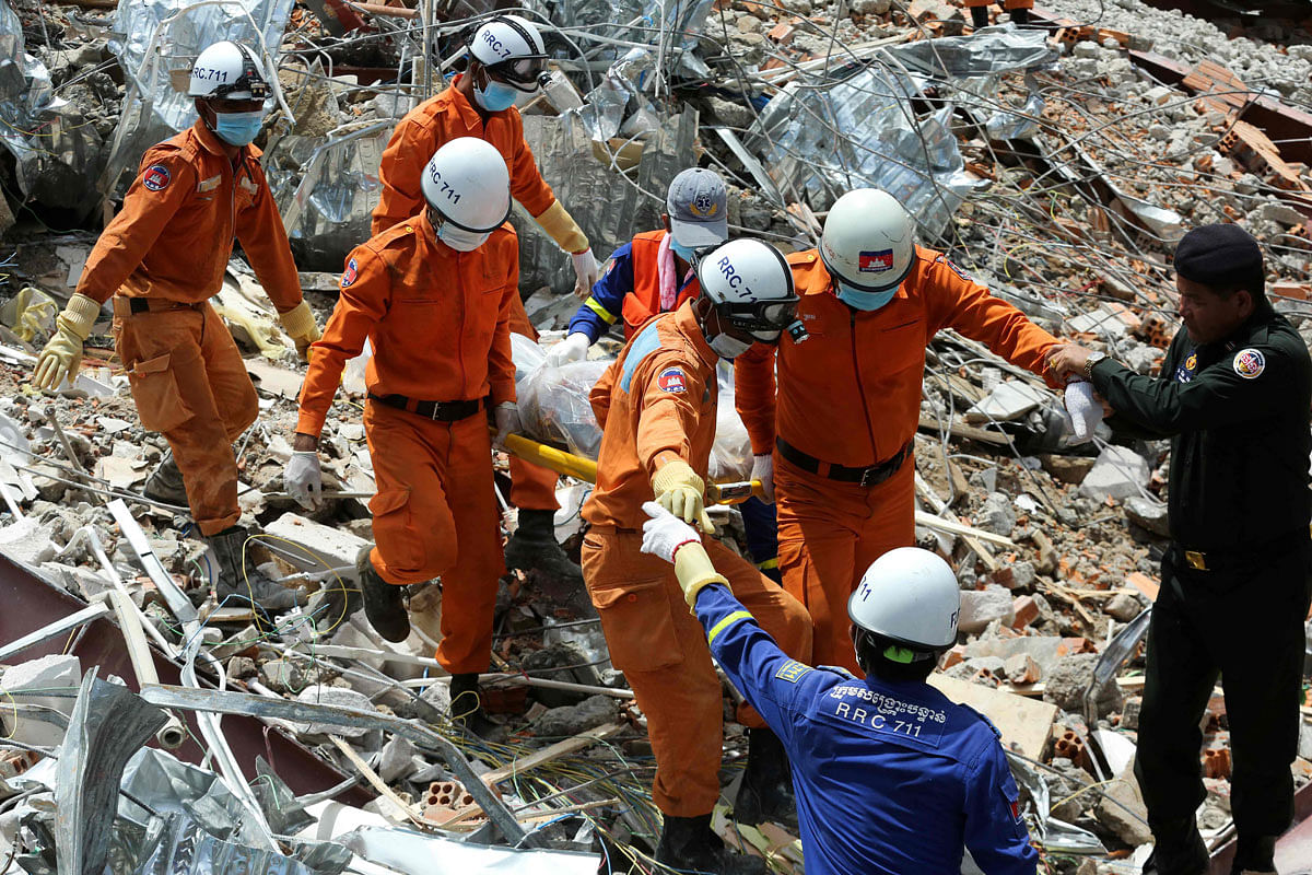 Rescue workers carry the body of a victim they dug out from debris a day after an under-construction building collapsed in Sihanoukville on 23 June 2019. Photo: AFP