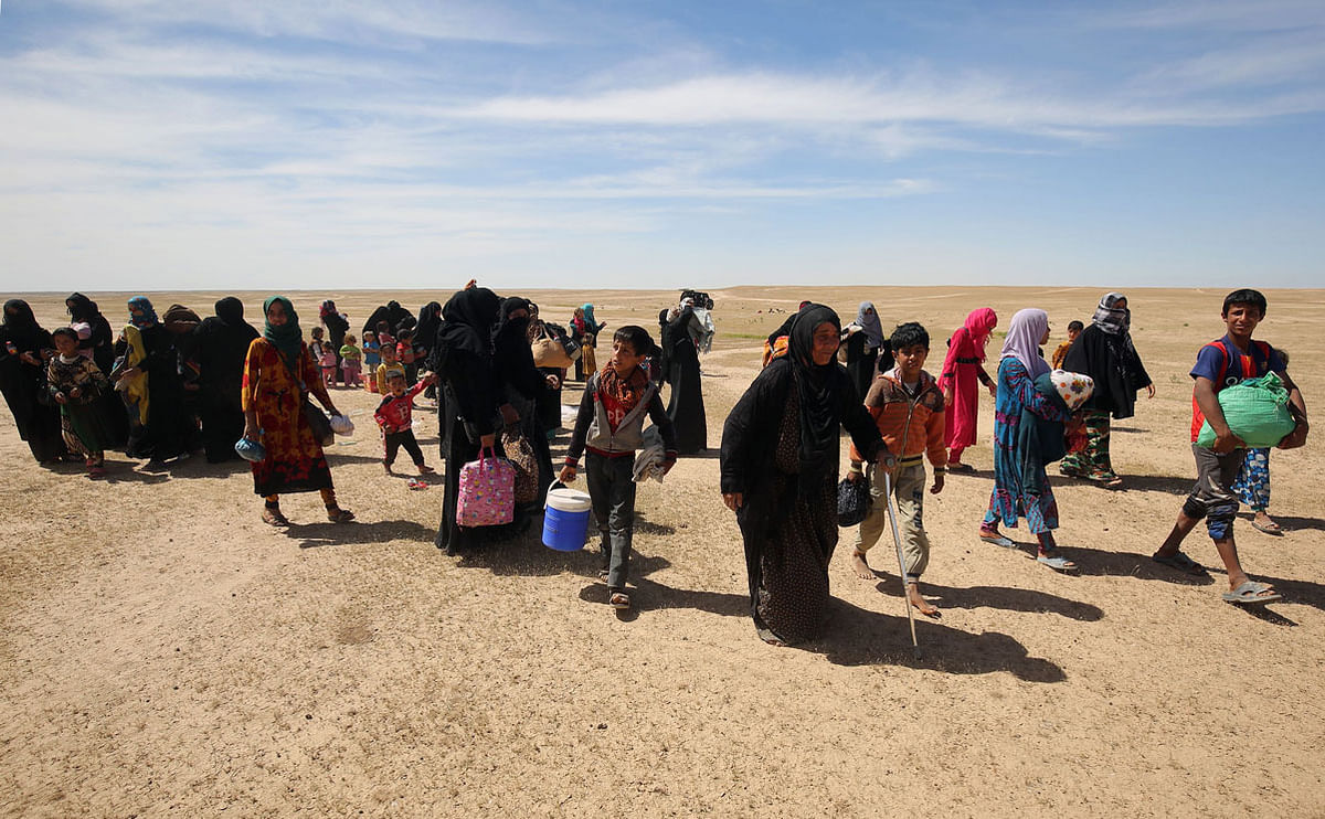 In this file photo taken on 26 April 2017 Displaced Iraqi families evacuate from the modern town of Hatra and neighbouring villages, near the eponymous UNESCO-listed ancient city, southwest of the northern city of Mosul, on 26 April 2017, as pro-government Hashed al-Shaabi (Popular Mobilisation) paramilitary forces advance during an offensive to retake the area from Islamic State (IS) group fighters. AFP File Photo