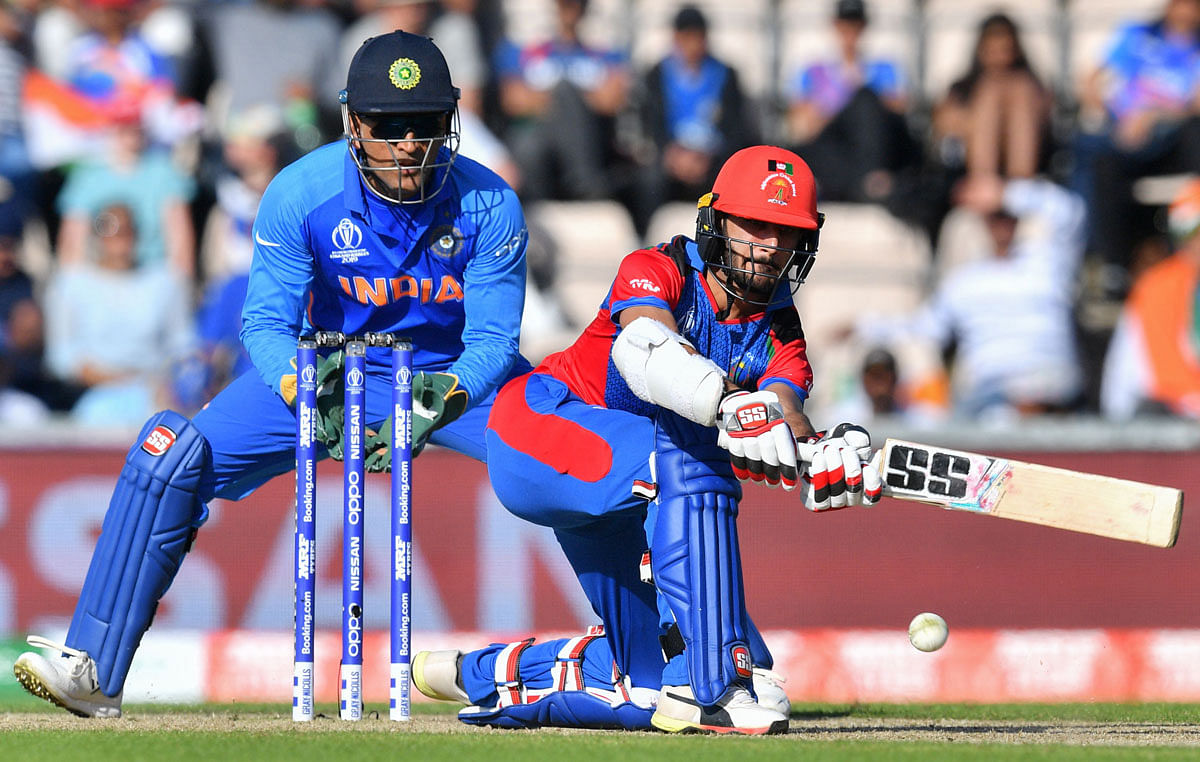 Afghanistan`s Ikram Ali Khil (R) plays a shot watched by India`s Mahendra Singh Dhoni during the 2019 Cricket World Cup group stage match between India and Afghanistan at the Rose Bowl in Southampton, southern England, on 22 June 2019. Photo: AFP