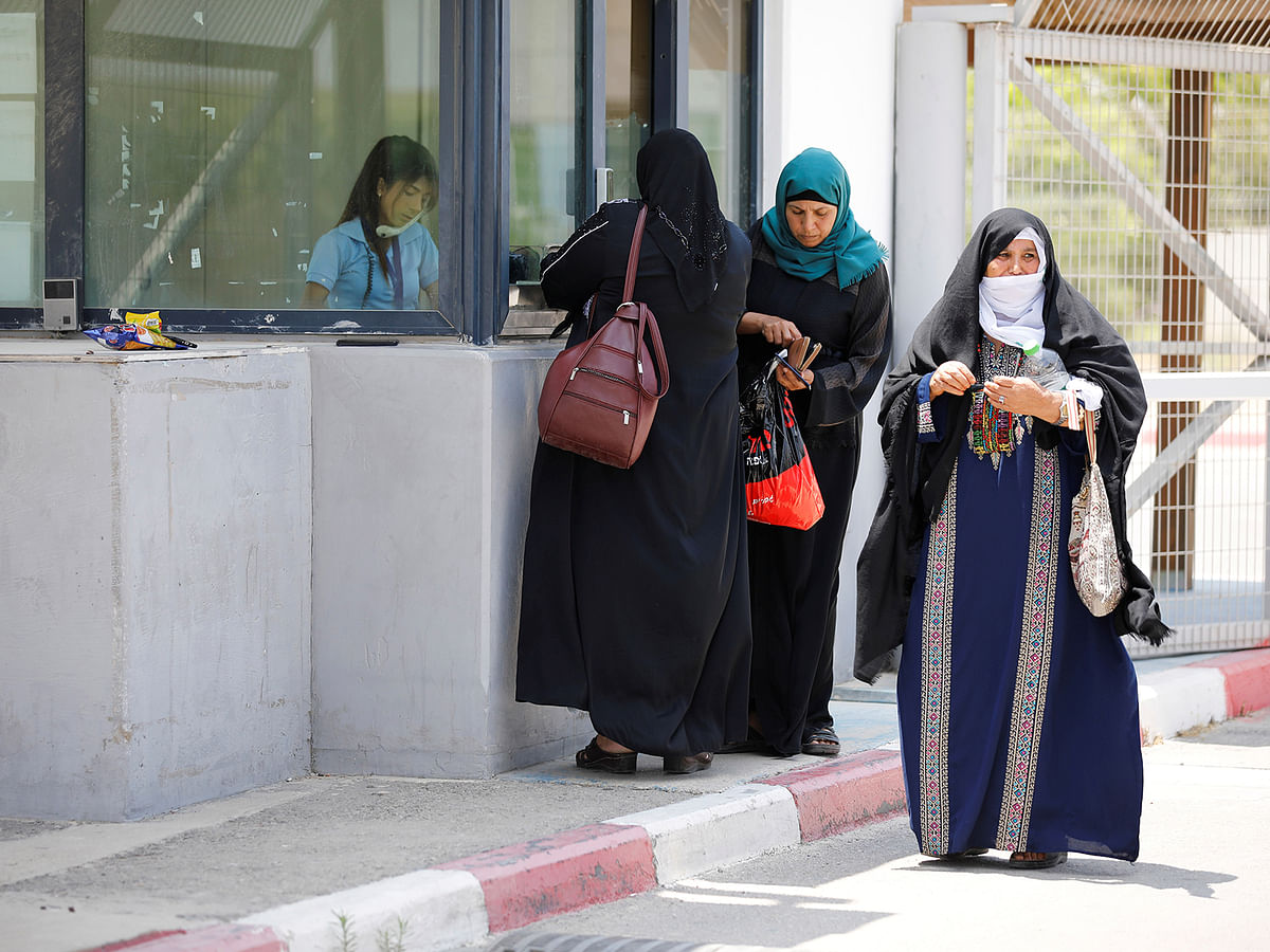 Palestinian women stand next to the counter of an Israeli official at the Israeli side of Erez crossing, on the border with Gaza on 23 June. Photo: Reuters