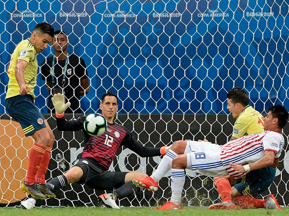 araguay`s goalkeeper Roberto Fernandez (C) eyes the ball as Colombia`s Radamel Falcao (L) and James Rodriguez (2-R) try to score during their Copa America football tournament group match at the Fonte Nova Arena in Salvador, Brazil, on 23 June 2019. Photo: AFP