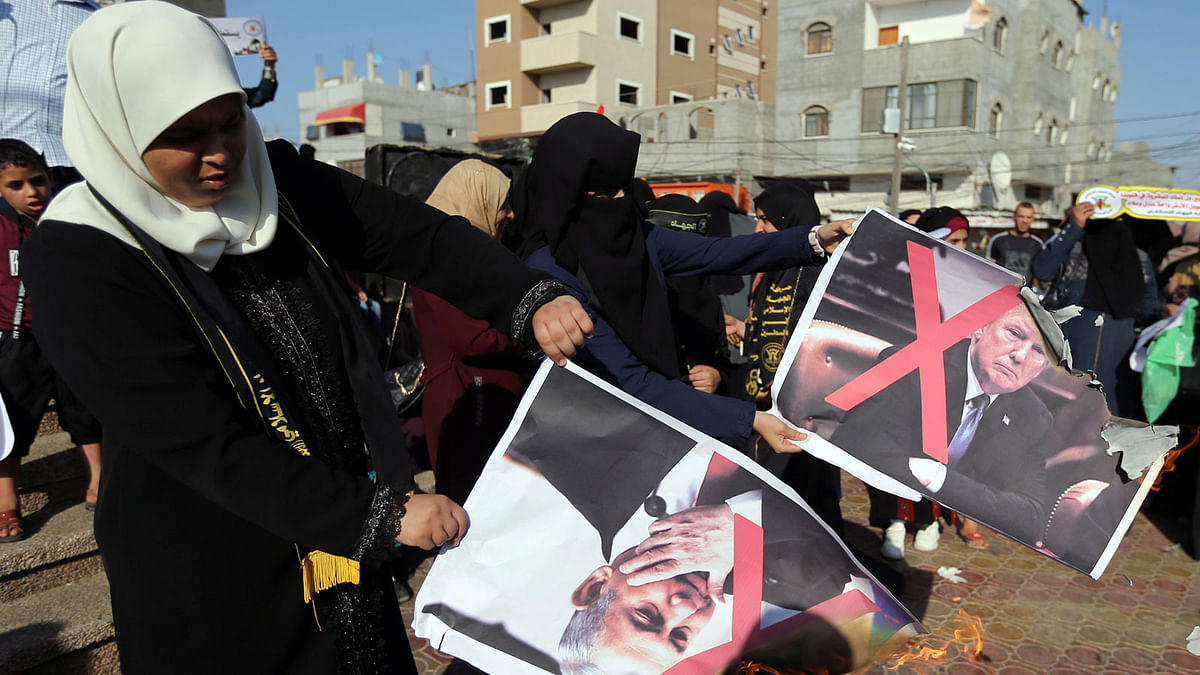 Palestinian women burn posters depicting US president Donald Trump and Israeli prime minister Benjamin Netanyahu during a protest against Bahrain`s workshop for US peace plan, in the southern Gaza Strip on 18 June. Photo: Reuters