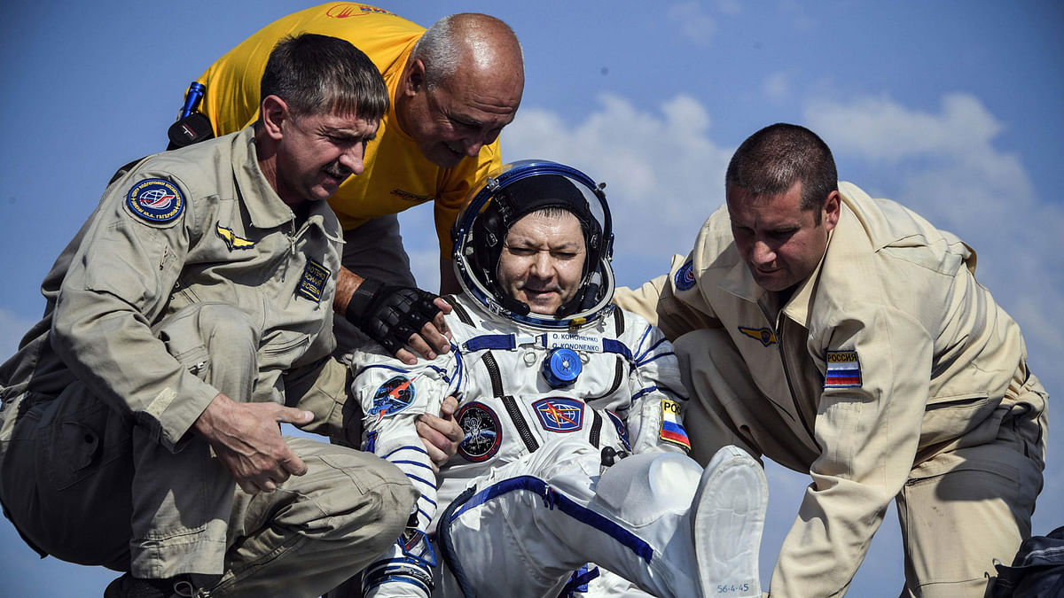 Ground personnel help Russian cosmonaut Oleg Kononenko to get out of the Soyuz MS-11 capsule shortly after landing in a remote area outside the town of Dzhezkazgan (Zhezkazgan), Kazakhstan, on 25 June 2019. Photo: AFP