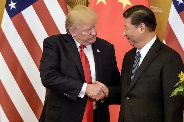 In this file photo taken on 9 November 2017, US president Donald Trump (L) shakes hand with China`s Xi Jinping in Beijing. Photo: AFP
